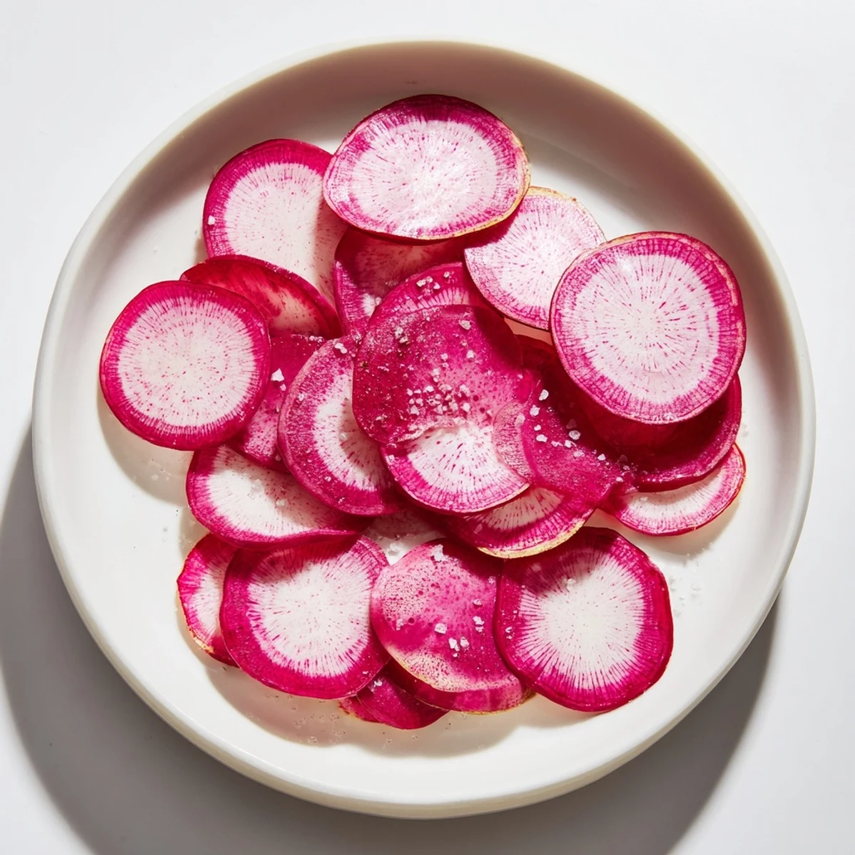 Thin, vibrant radish slices sprinkled with sea salt, an easy and healthy snack option.