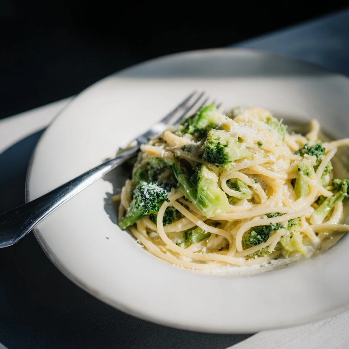 One-Pot Lemon Broccoli Pasta with bright green florets coated in a silky garlic sauce, served steaming in a white bowl.