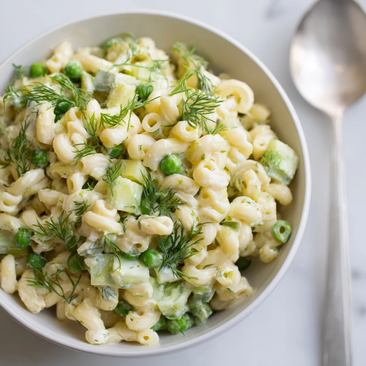 Close-up of Creamy Dill Pickle Pasta Salad showing crunchy celery, red onion, and creamy dressing tossed with pasta for a tangy, refreshing bite.