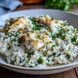 Golden Smoked Haddock Risotto served with a glass of white wine and crusty bread.
