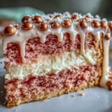 A delicate pink velvet cake made with rosé wine, layered with silky cream cheese frosting and finished with a luxurious edible gold drip for a bridal shower centerpiece.