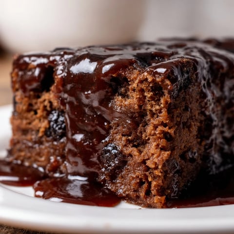 Warm, inviting shot of the finished Weekend Cabin-Style Sticky Toffee Pudding drizzled with golden toffee sauce.