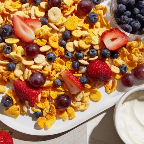 Golden, colorful pile: Rainbow Goldfish crackers mingled with fresh, vibrant fruits and creamy yogurt dip.