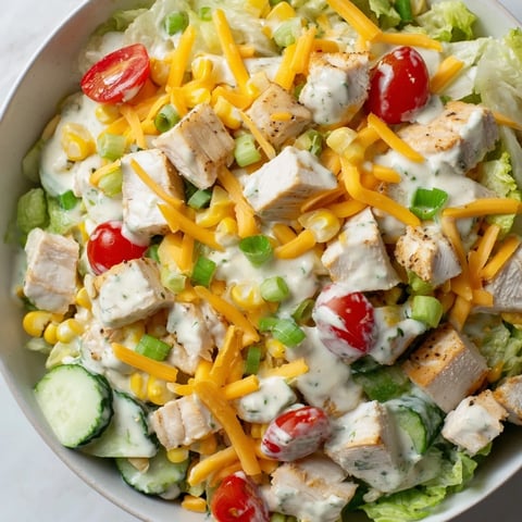 A close-up of Ranch Chicken Chopped Salad with crisp romaine, juicy tomatoes, and tender chicken tossed in creamy dressing.