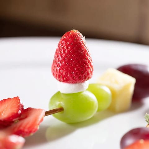 Vibrant Christmas Light Fruit Skewers sparkle with colorful grapes, strawberries, and pineapple, a healthy holiday snack.