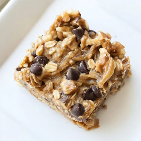 Textured close-up of Peanut Butter Banana Oat Bars, showing oats, nuts, and chocolate chips.