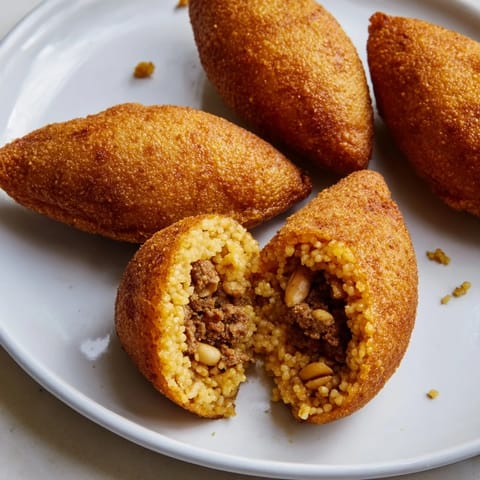 A close-up shot of baked Lebanese Kibbeh revealing its inviting aroma and flavorful, tender texture.