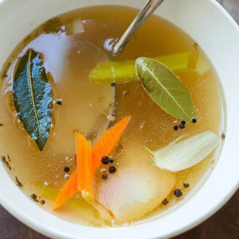 Homemade Vegetable Broth From Scraps strained into a clear glass jar, ready for soup bases or sipping.