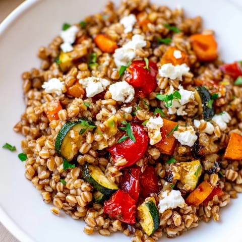 A close-up of warm, caramelized vegetable medley served over hearty farro.