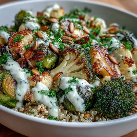A close-up of a Roasted Brassica Bowl highlights crisp vegetables and a creamy tahini-lemon drizzle. 