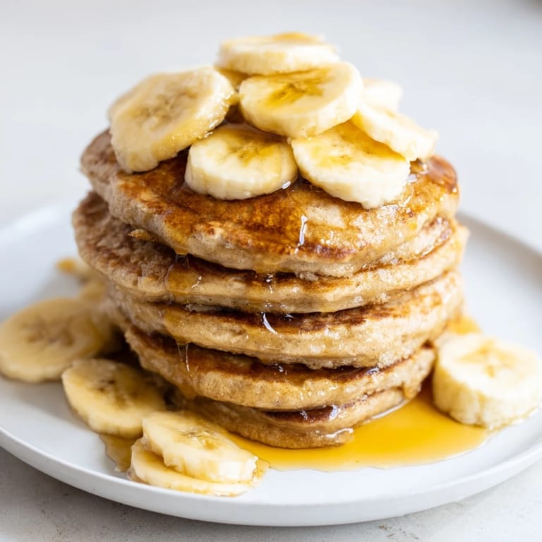 Fluffy weekend golden-brunch banana pancakes feature sliced bananas, creating a delicious and inviting breakfast.