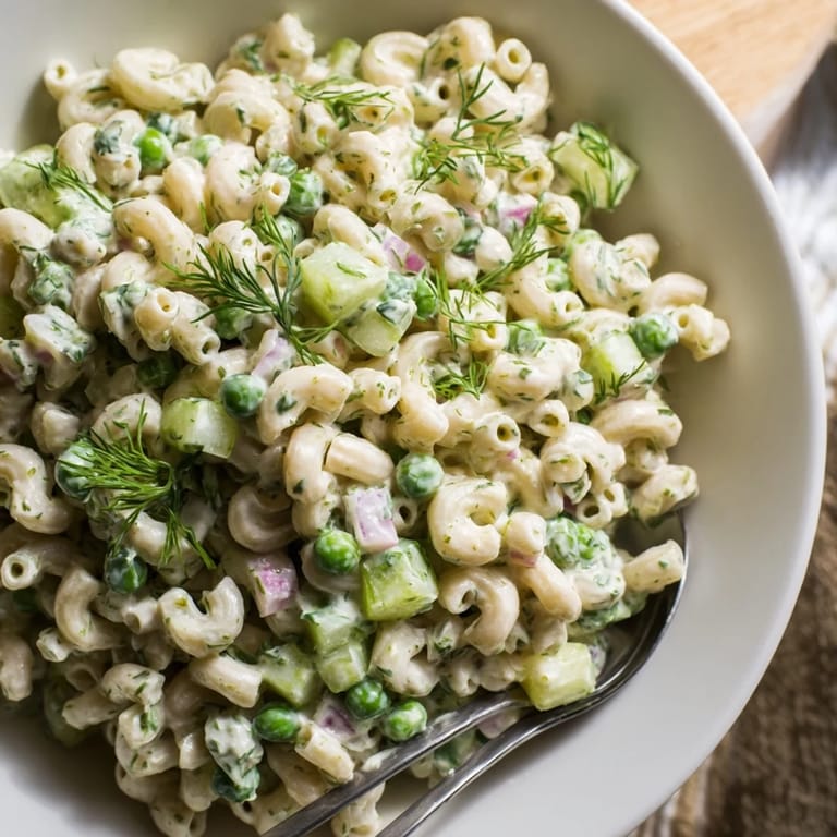Creamy Dill Pickle Pasta Salad in a white bowl, garnished with fresh dill and served chilled as a perfect spring or summer side dish.  