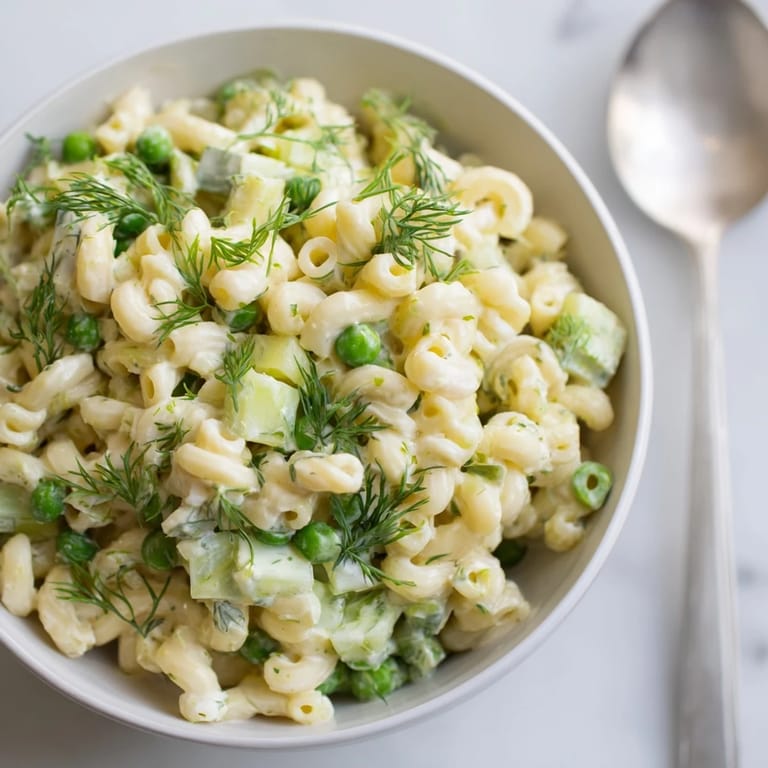 Close-up of Creamy Dill Pickle Pasta Salad showing crunchy celery, red onion, and creamy dressing tossed with pasta for a tangy, refreshing bite.