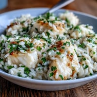 Creamy Smoked Haddock Risotto in a white bowl, topped with fresh parsley and lemon zest.