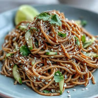 Chilled soba noodle salad with sesame ginger dressing, a vibrant vegetarian dish.